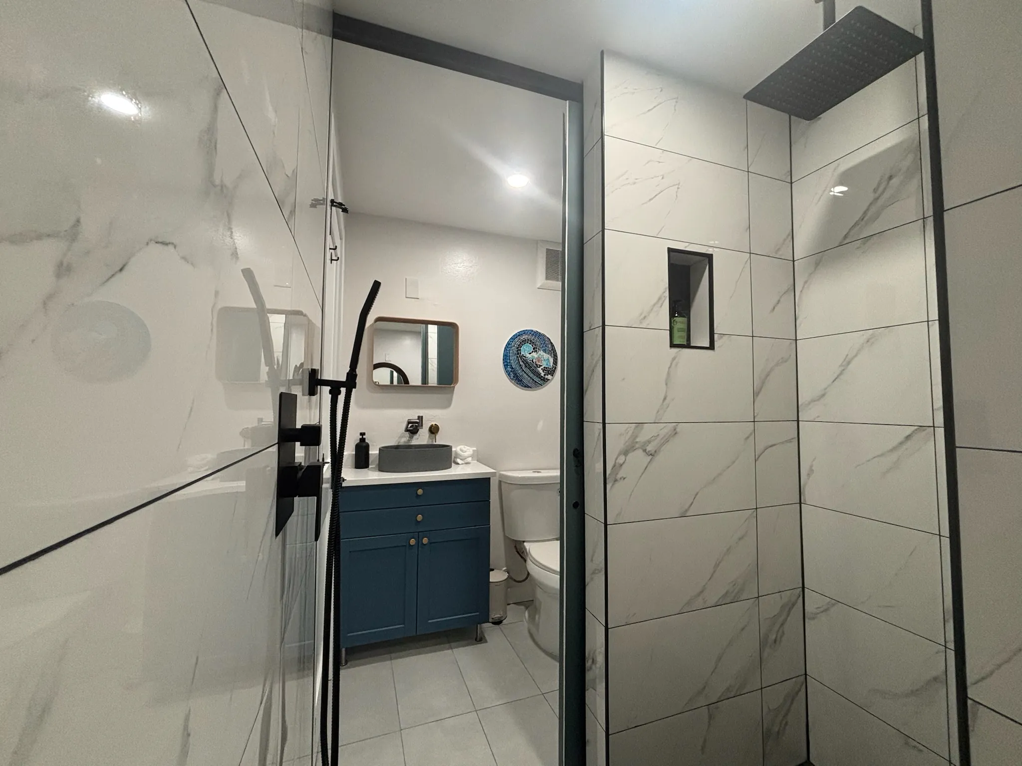 Marble-tiled walk-in rainfall shower in the Main House