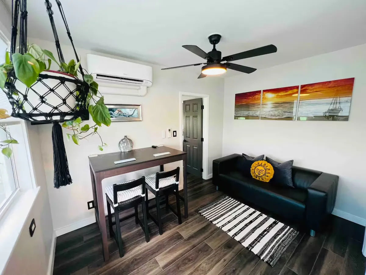 Octopus Loft living room with a sofa, dining table for two and sunset artwork